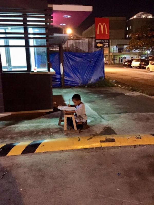 Мальчик делает уроки при свете от «Макдоналдса»